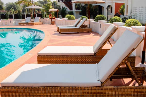 Chairs around the pool with beautiful umbrellas in the resort of the hotel.